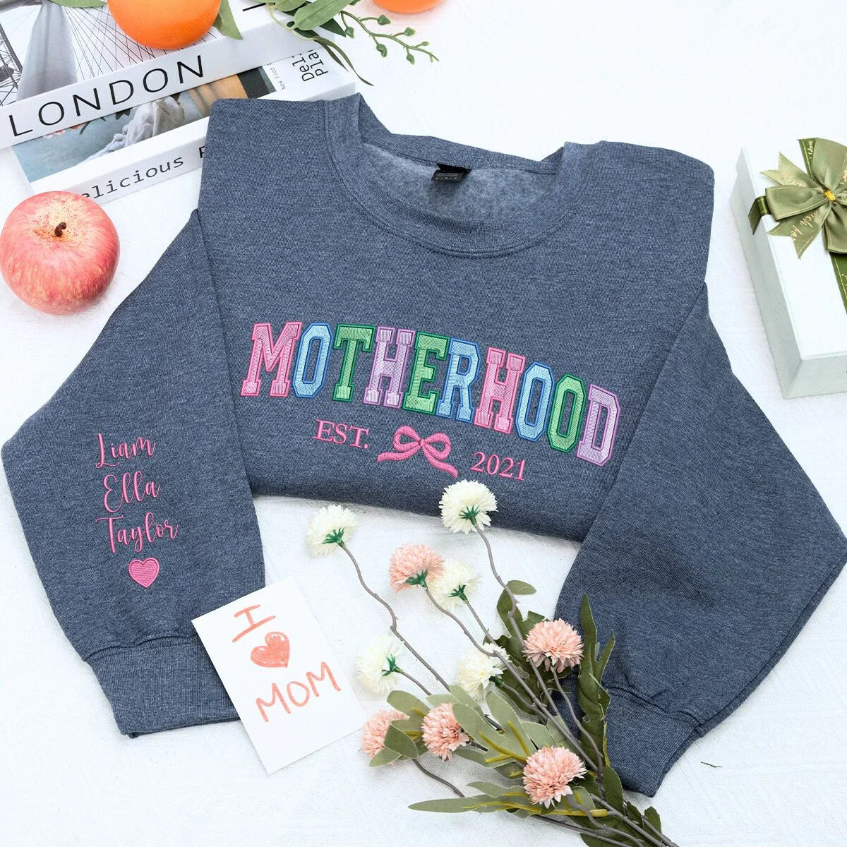 Motherhood Sweatshirt or Hoodie with Coquette Bow and Kids Names on Sleeve, Custom Embroidered Gift for Mother's Day